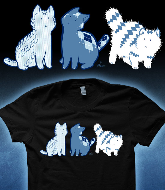 On a black shirt there are 3 different kittens with blue accents that are made out of different sweater patterns, one has a corded design and a knitted texture, one medium blue one has an Argyle pattern, and the last white one is a long hair angora kitten with a diamond pattern.